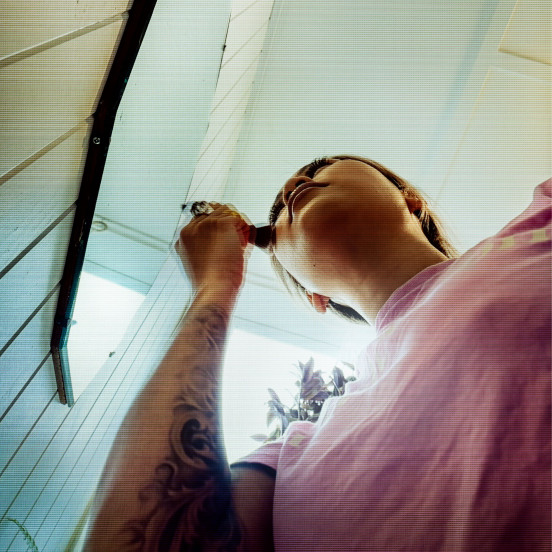 Photo of a woman looking in the mirror, taken from below looking up at her