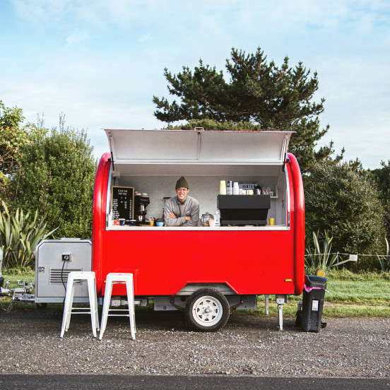 Woman standing behind the counter of a bright red food truck