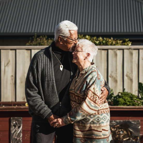 Older man hugging older woman and holding hands