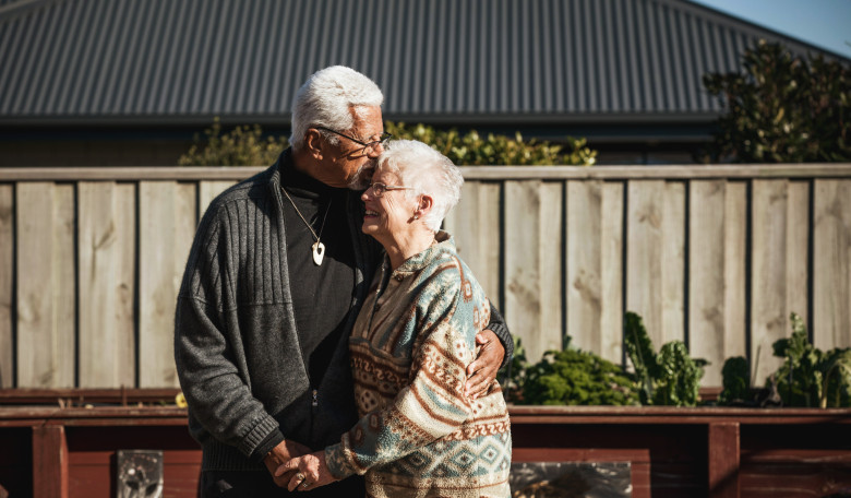 Older man hugging older woman and holding hands