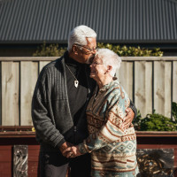 Older man hugging older woman and holding hands