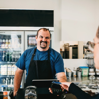 Cafe owner serving customer at the till