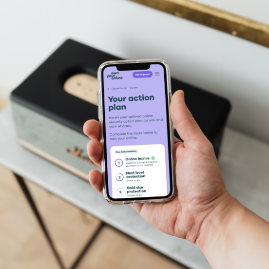 Photo of a man's hands holding a mobile phone with webpage showing the words Your action plan.
