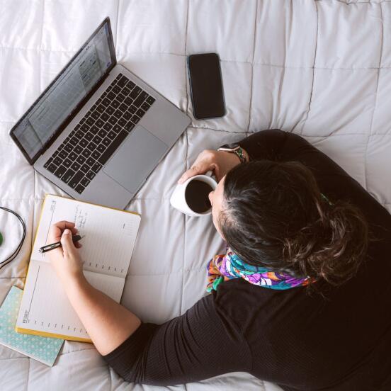 Woman on bed using laptop